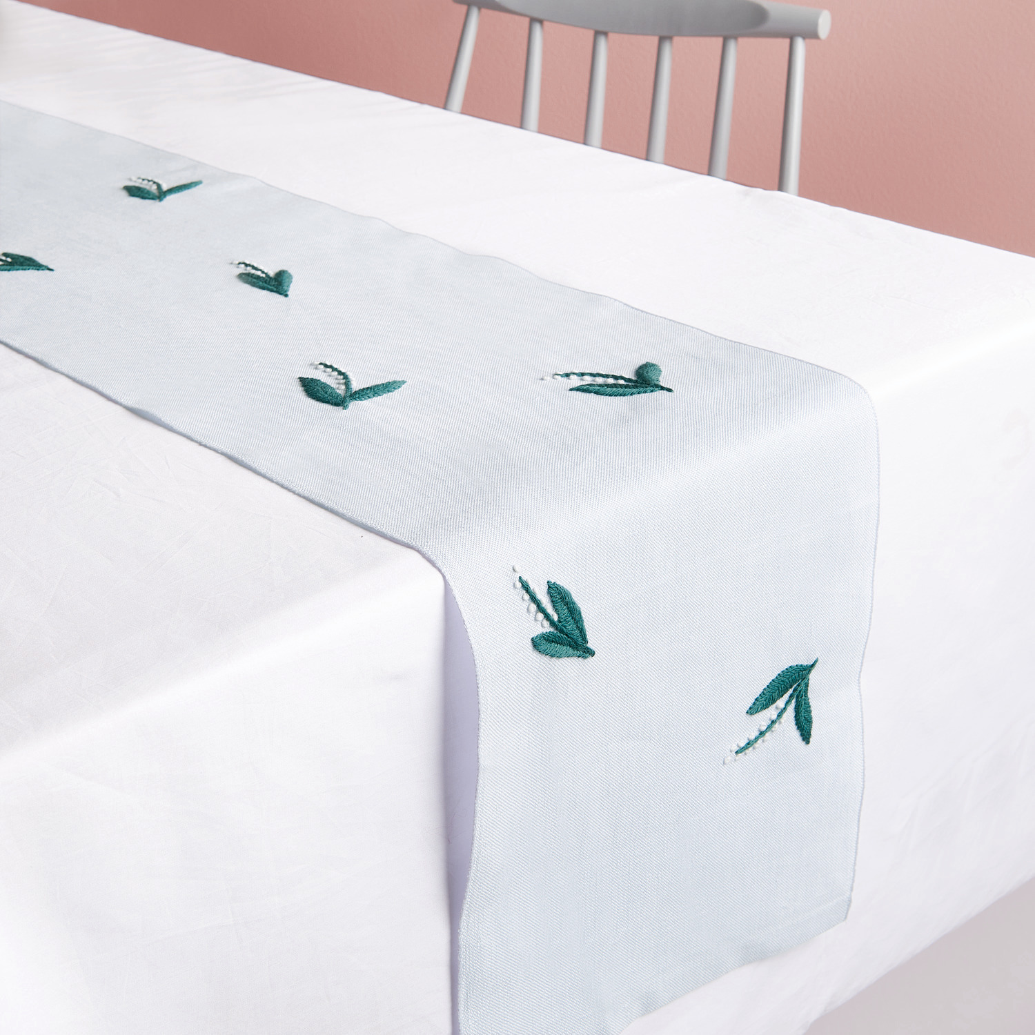 Stickpackung Tischband Maiglöckchen vorgezeichnet, 30x146cm, auf weißem Tisch mit grünen Stickereien. Ideal für elegante Tischdekoration.