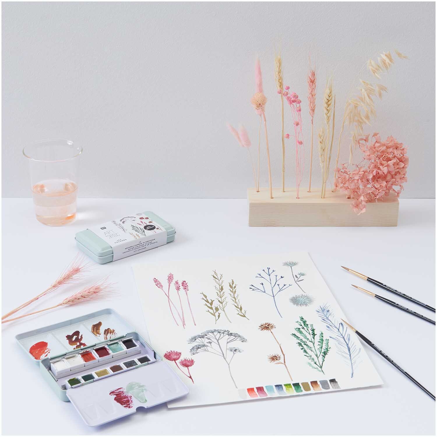 ART Essential Aquarellfarben Icy Colours 12 Farben, mit Pinsel und Blumenillustration auf weißem Papier.