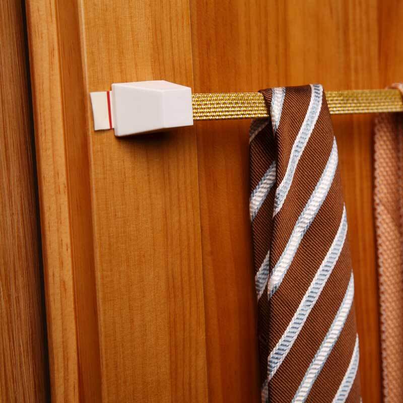 Powerstrips large 10 Stück: Ein weißer Klebestreifen von tesa hält eine gestreifte Krawatte an einer Holztür.