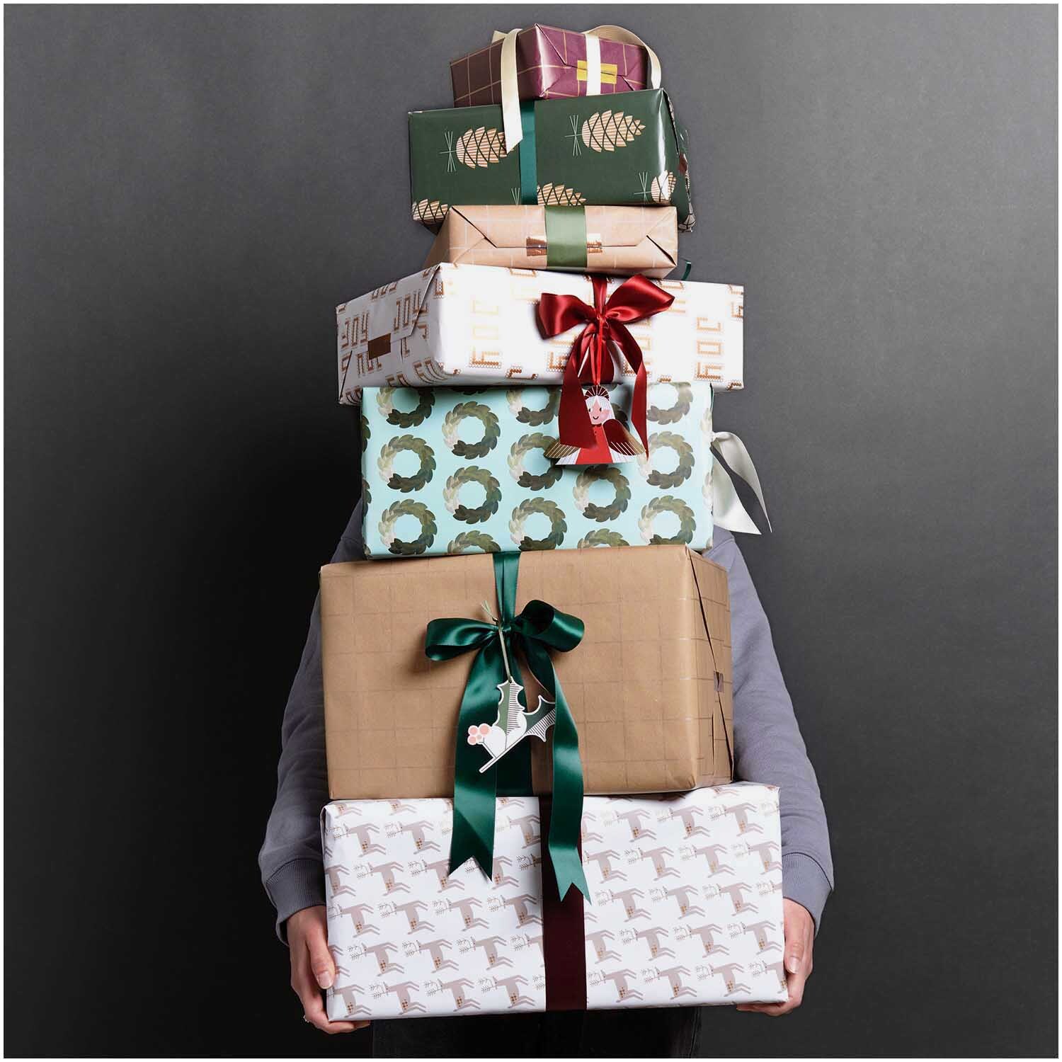 Paper Poetry Geschenkpapier Kränze grün: Stapel von Geschenken mit dekorativem Papier und Schleifen.