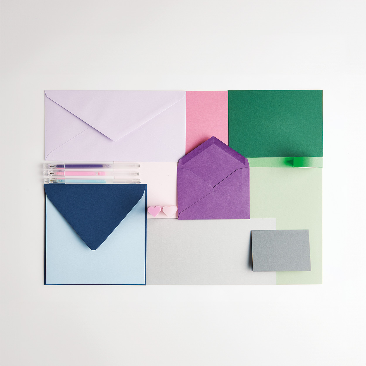 Verschieden große lila, pinke, grüne, graue und blaue Karten und Umschläge aus der Serie Paper Poetry Essentials.