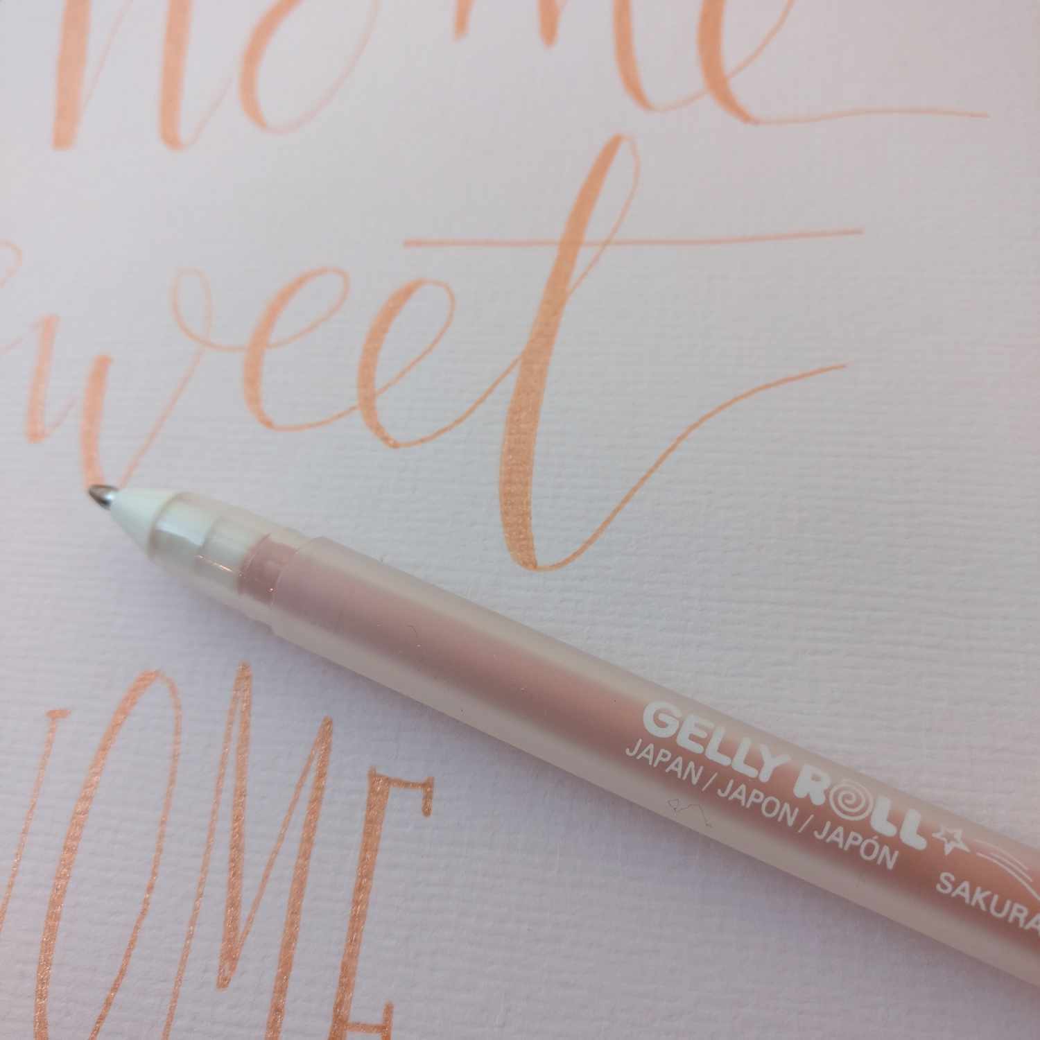Gelly Roll Stardust Glitter Gelstifte Set 12 Stück von SAKURA auf rosa Papier mit Schriftzug.