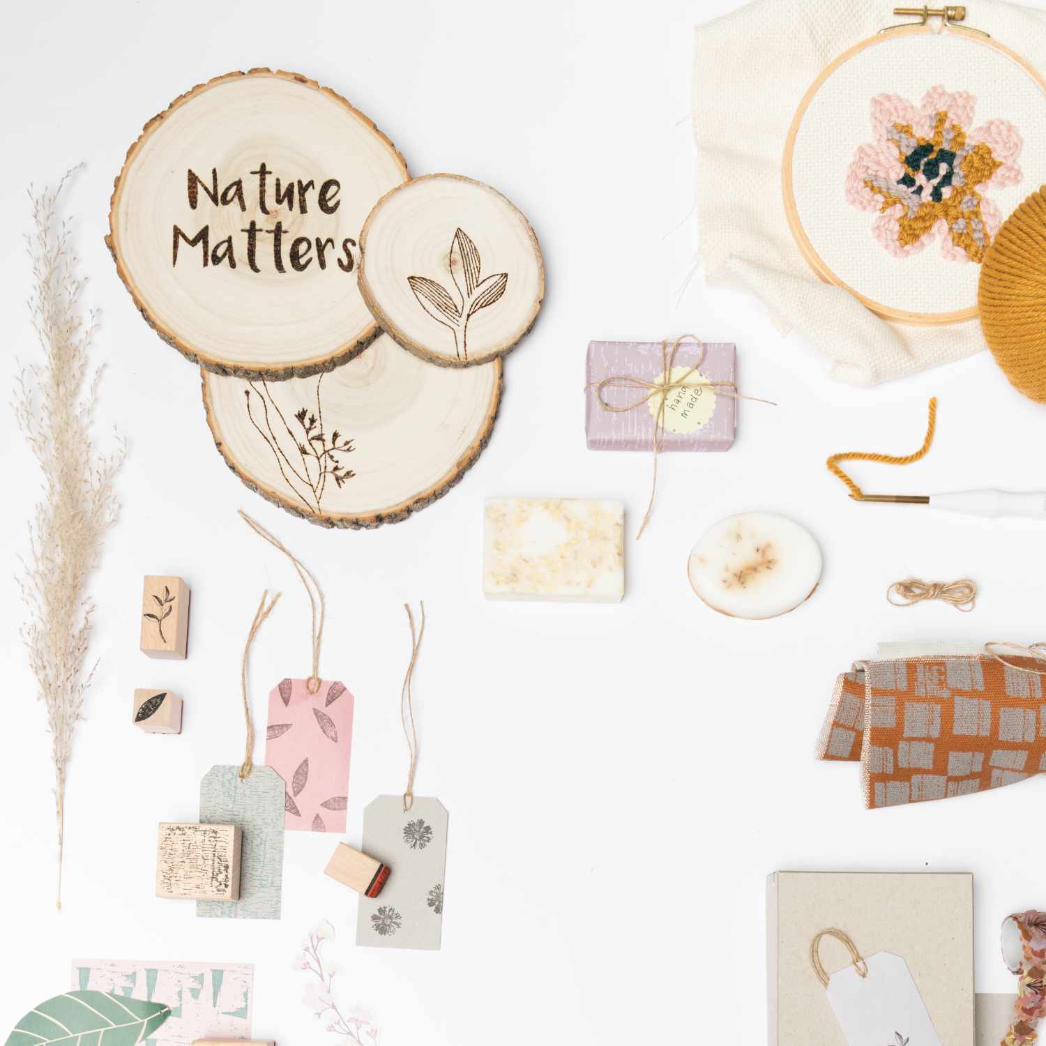 Große, beige Holzscheibe von Rico Design mit einem Durchmesser von 16-19 cm und einer Dicke von 1,5 cm. Auf der Scheibe steht "Nature Matters". Umgeben von Bastelmaterialien und dekorativen Elementen.