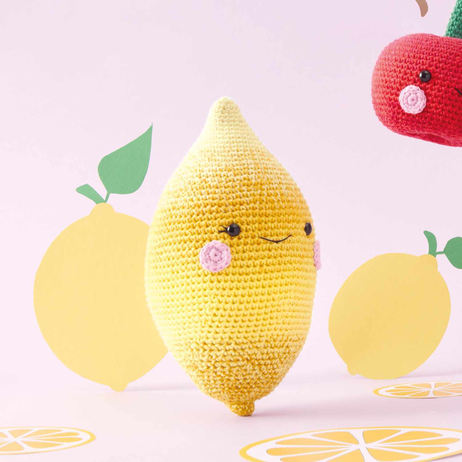 Häkelset Zitrone aus Ricorumi Fresh Friends: Gelbe gehäkelte Zitrone mit Gesicht, umgeben von Zitronenmotiven.
