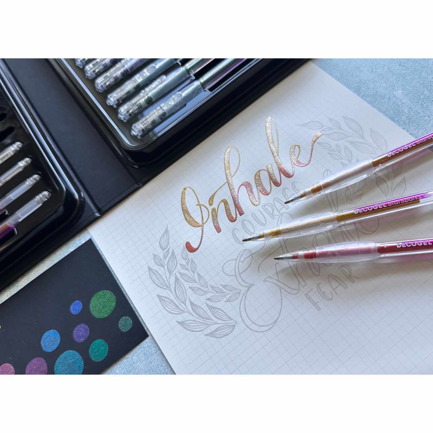 Decogel-Set Star Sparks 20 Stück: Kreatives Handlettering mit bunten Stiften auf Papier, umgeben von einem eleganten Blattmuster.