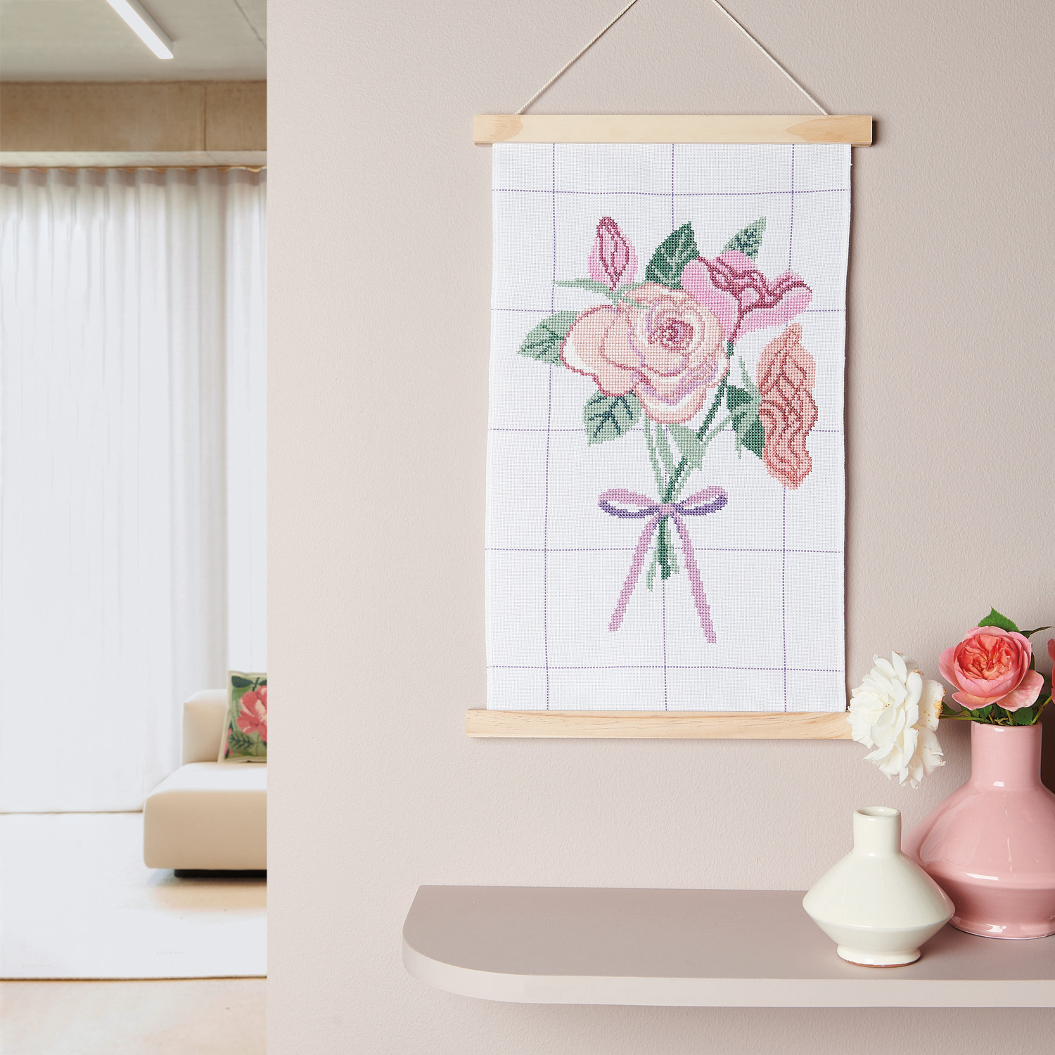 Stickpackung Bild Blumenstrauß mit Posterhänger zeigt ein florales Design in Pastelltönen, aufgehängt an einer Wand. Ideal für kreative Dekoration.
