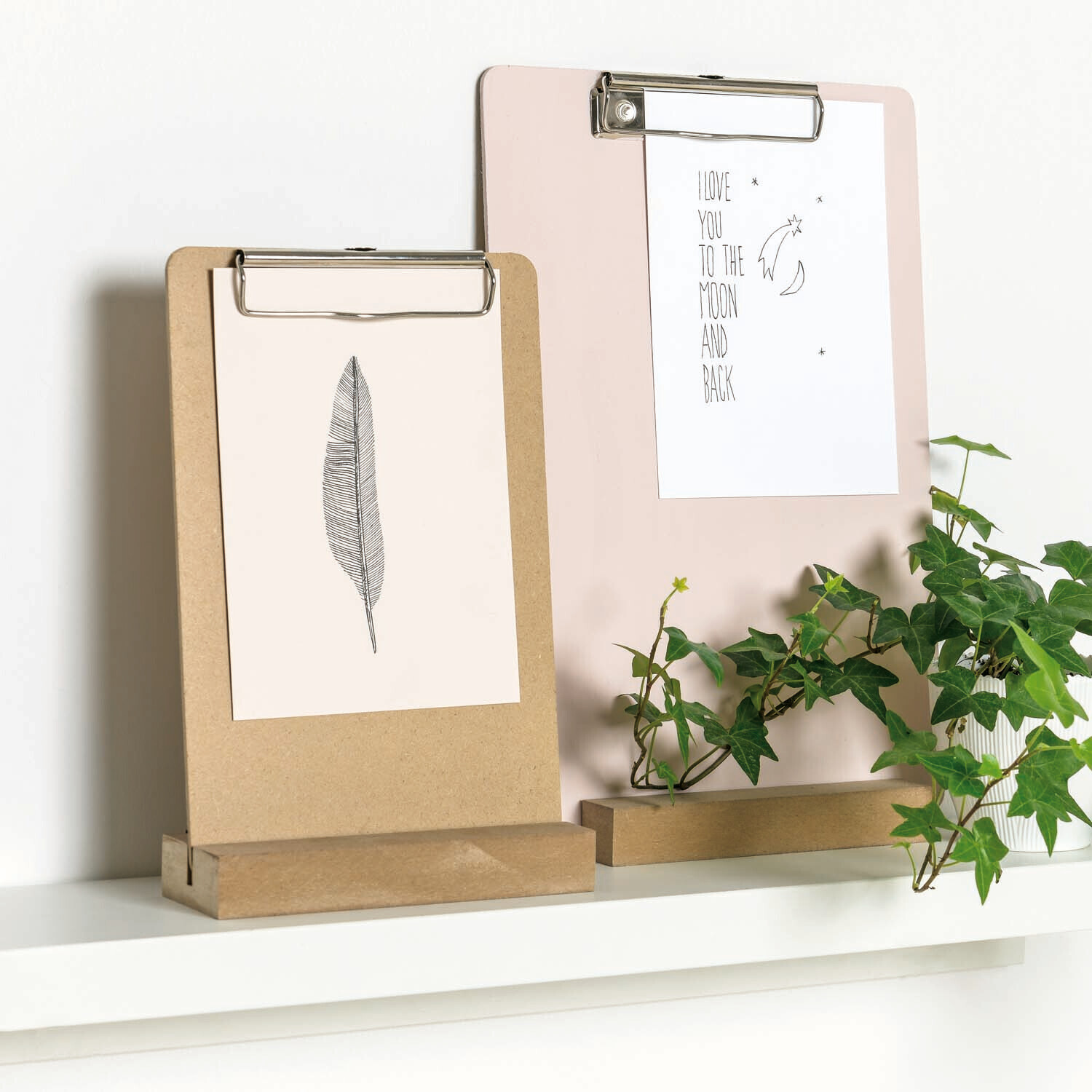 Klemmbretthalter natur von Rico Design auf einem Regal, dekoriert mit Pflanzen und Zeichnungen.