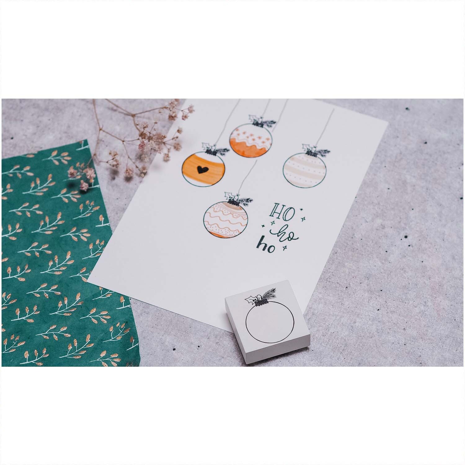 Stempel Weihnachtskugel weiß 45x45mm von May&Berry neben einer Karte mit gezeichneten Weihnachtskugeln und dem Schriftzug "Ho ho ho".