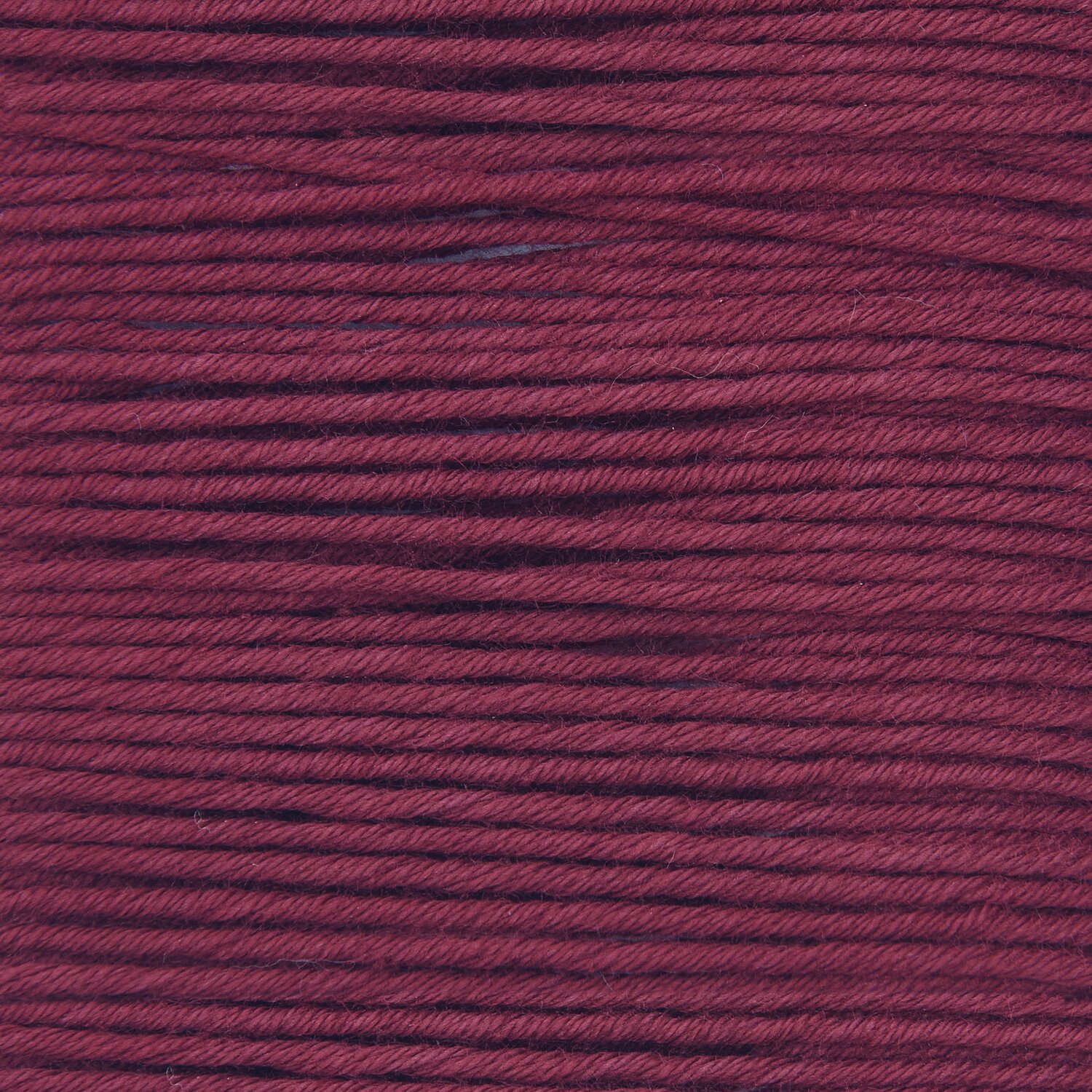 Essentials Organic Cotton aran in weinrot von Rico Design, Nahaufnahme der weichen, dichten Fasern. Ideal für Strickprojekte, 50g 90m.