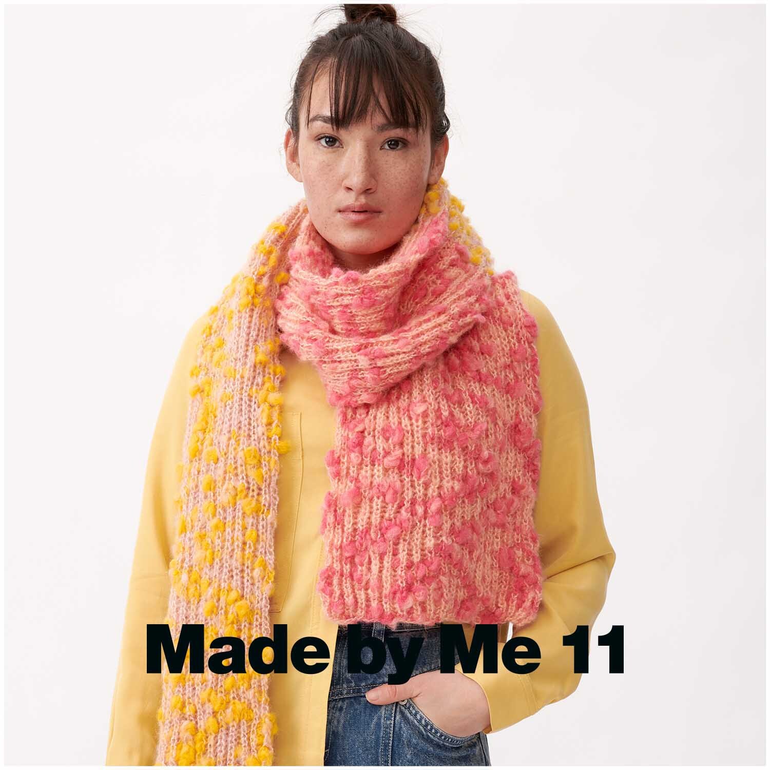 Fashion Alpaca Vibes aran: Frau trägt gestrickten Schal in Lachs-Gelb von Rico Design, kombiniert mit gelbem Oberteil.