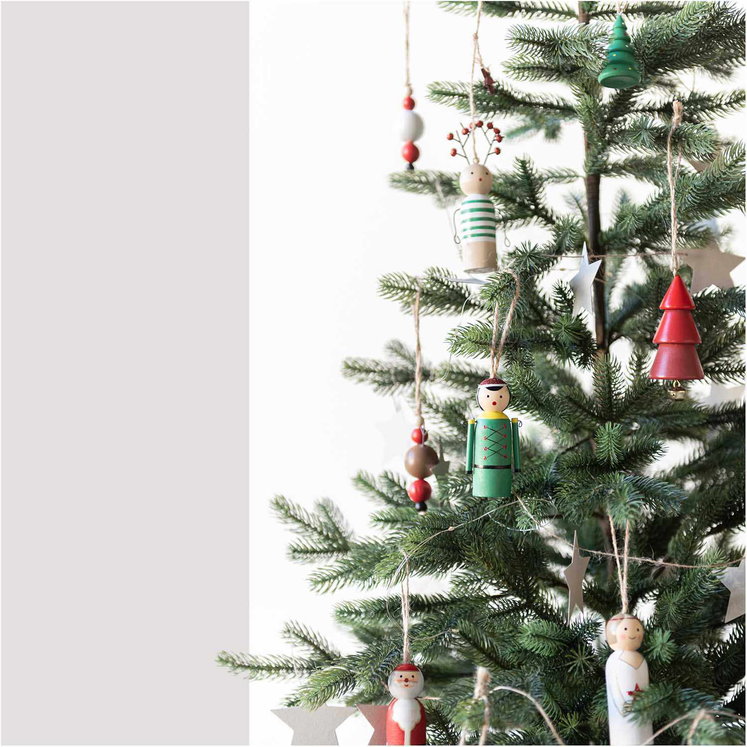 Holzhänger Nussknacker rot 3x9cm von Rico Design an einem Weihnachtsbaum mit weiteren Holzornamenten.