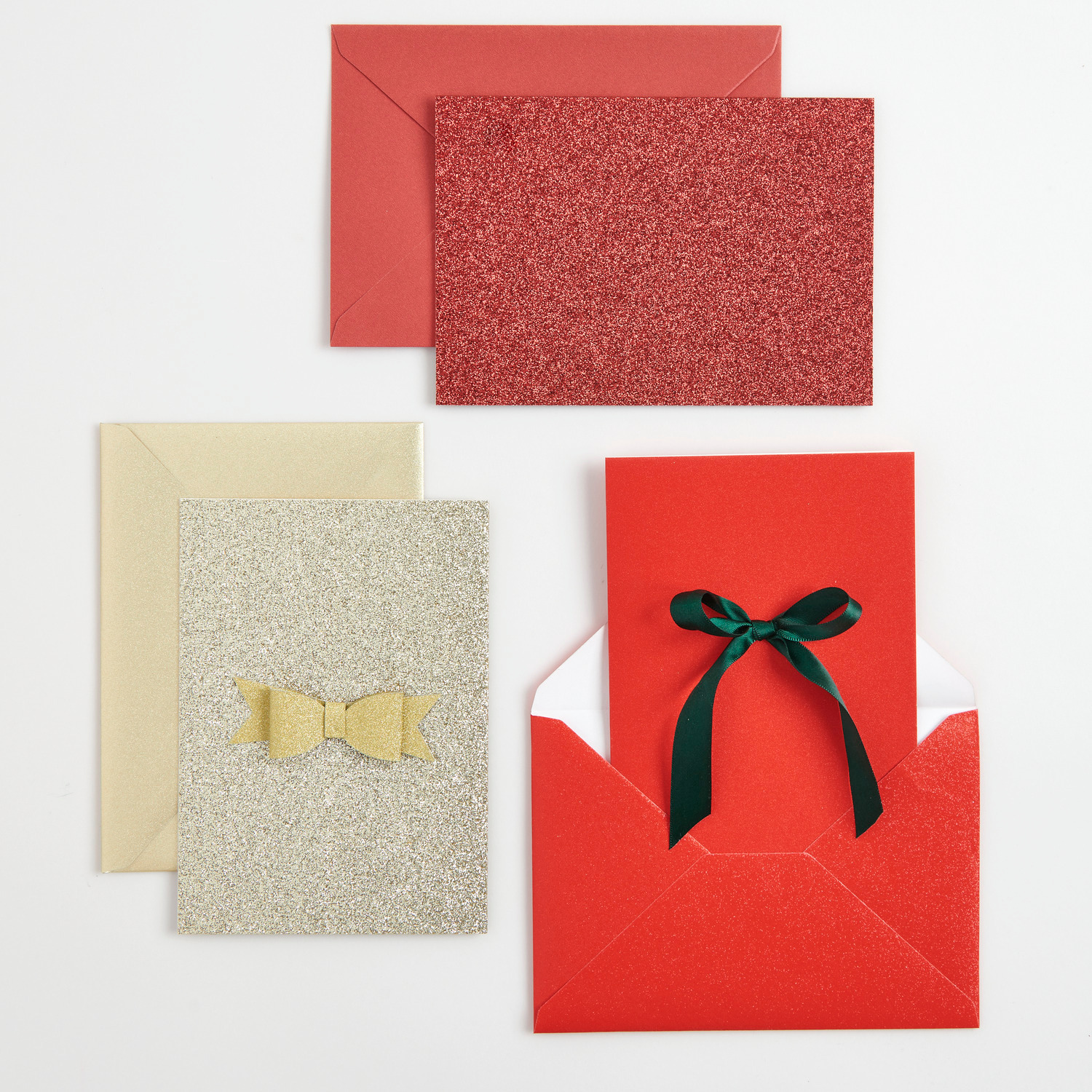 Paper Poetry Karten- und Umschlagset Glitter B6 Gold: Elegantes Set mit goldenen und roten Karten, verziert mit Schleifen, ideal für festliche Anlässe.
