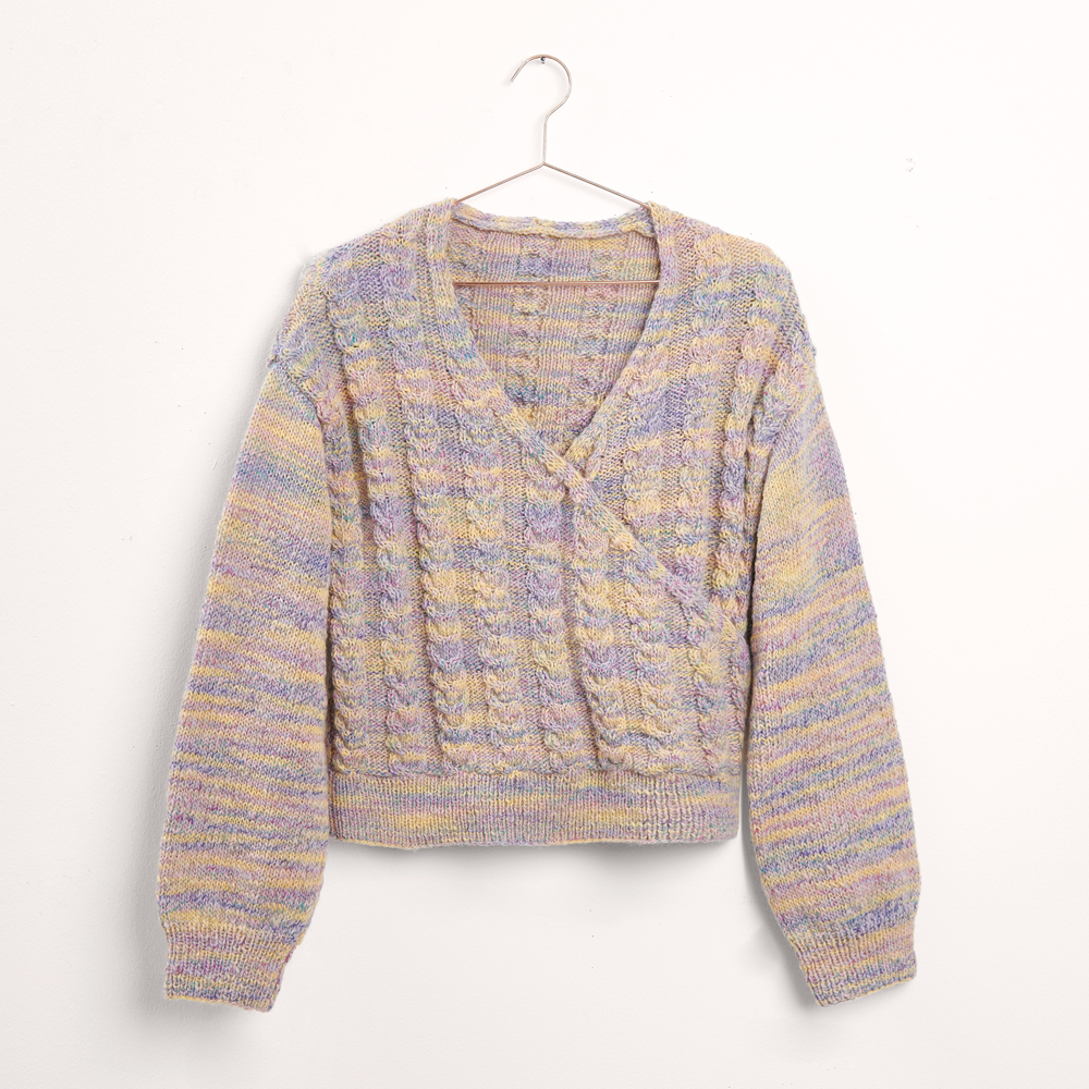 Pullover mit Zopfmuster auf grauem Hintergrund – zum Strickset