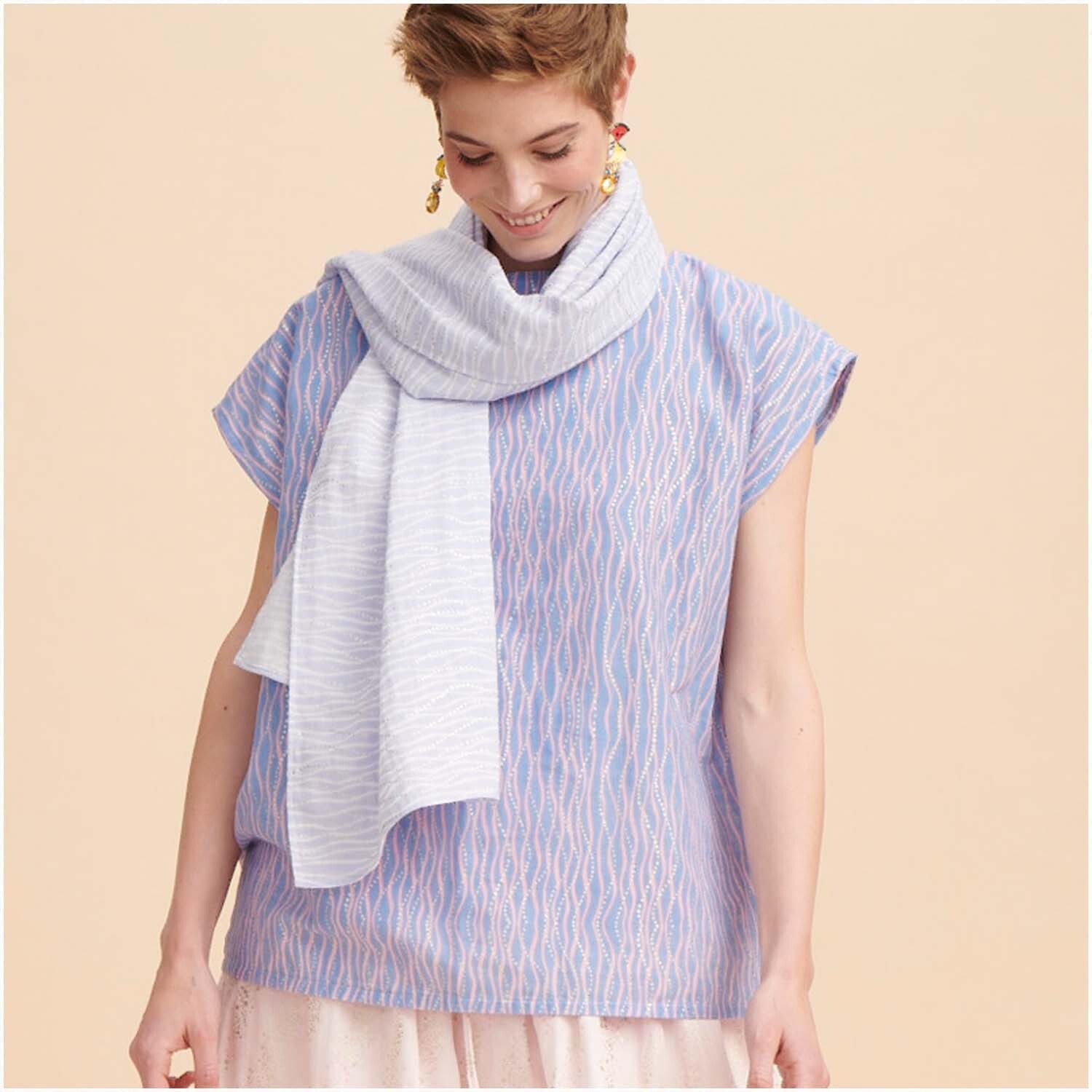 Musselin-Druckstoff Mermaid Wellen blau von Rico Design: Frau trägt ein blaues Oberteil mit wellenförmigem Muster und passendem Schal.
