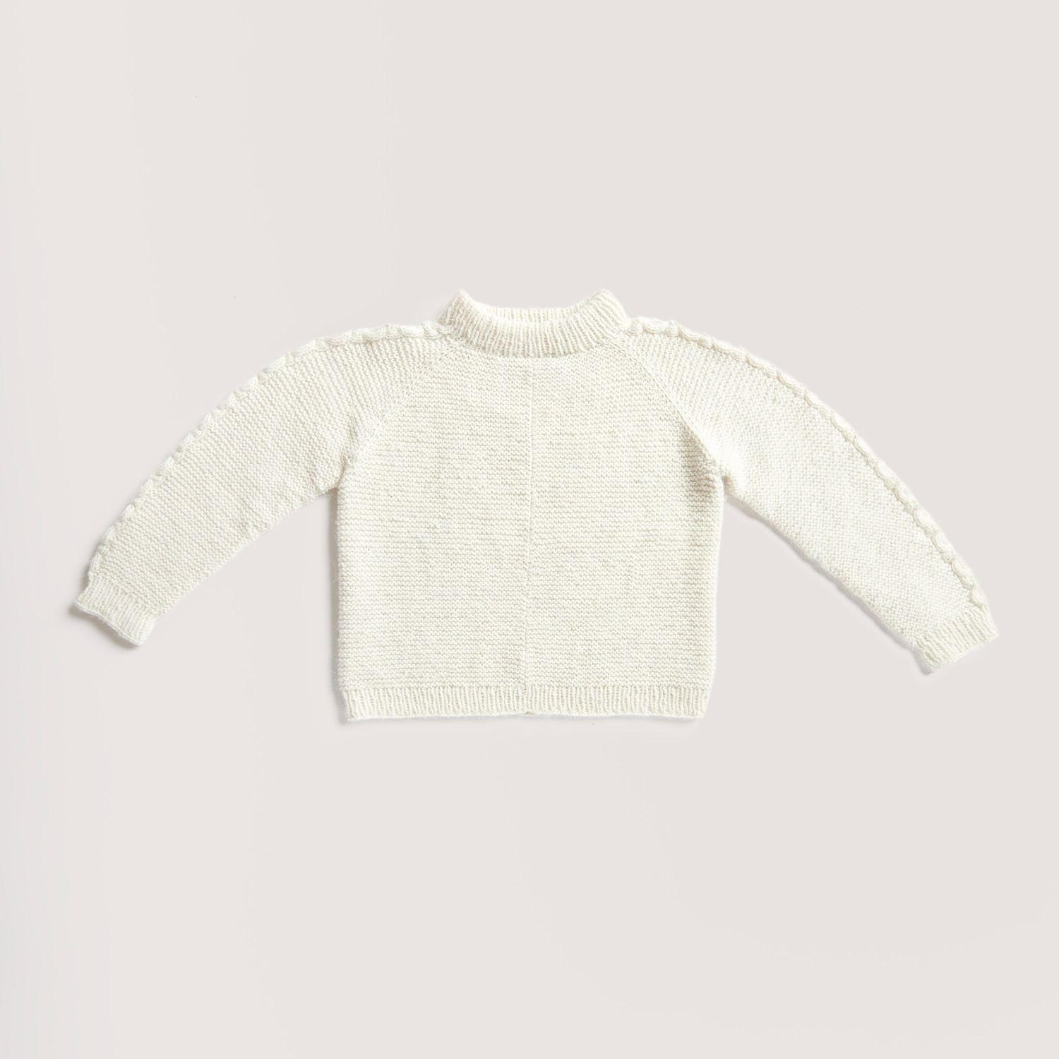 Strickset Pullover Modell 15 aus Rico Kids 13 zeigt einen cremefarbenen Kinderpullover aus weicher Alpaka-Wolle, perfekt für kühle Tage.