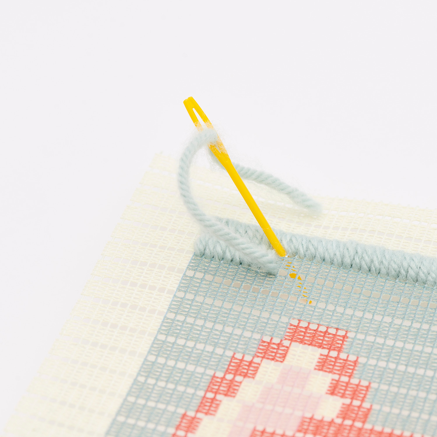 Longstitch Stickpackung Fuchs zeigt eine Nahaufnahme einer Sticknadel auf einem bunten Stoff.