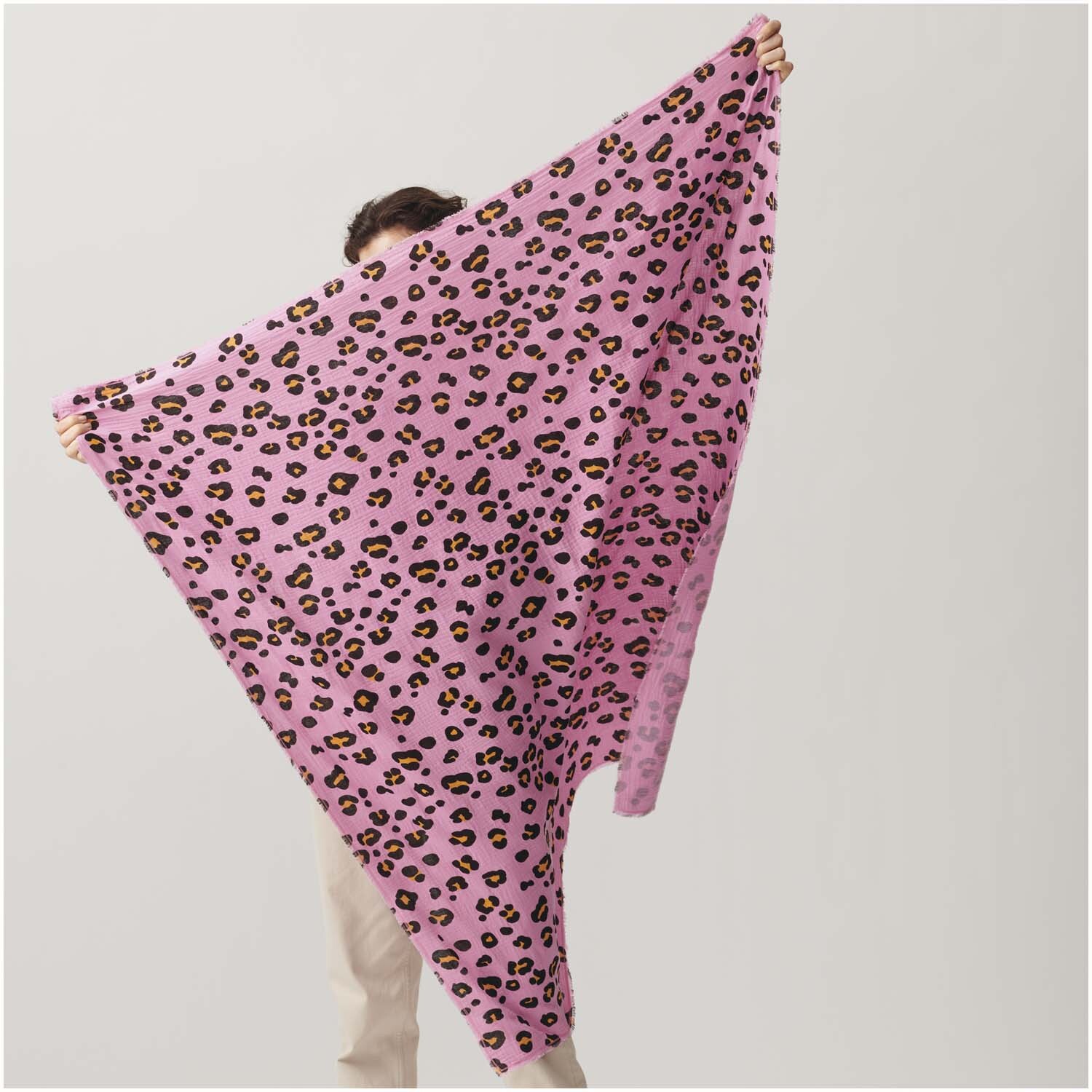 Meterware Krinkelmusselin Acid Leo pink: Person hält pinken Stoff mit Leopardenmuster von Rico Design. Ideal für kreative Nähprojekte.