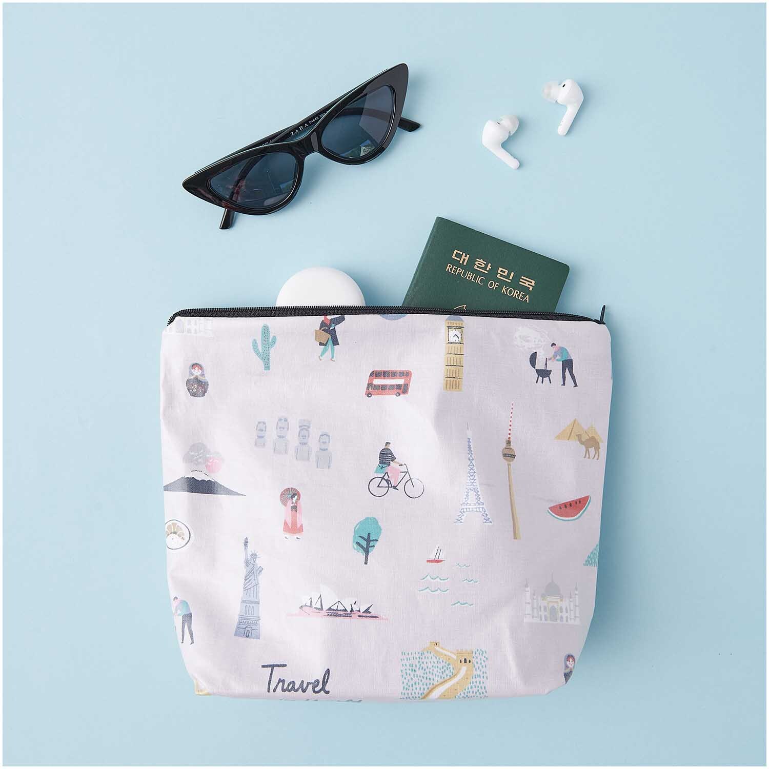 Kosmetiktasche Travel the World mit Reise-Motiven, Sonnenbrille und Reisepass auf blauem Hintergrund.