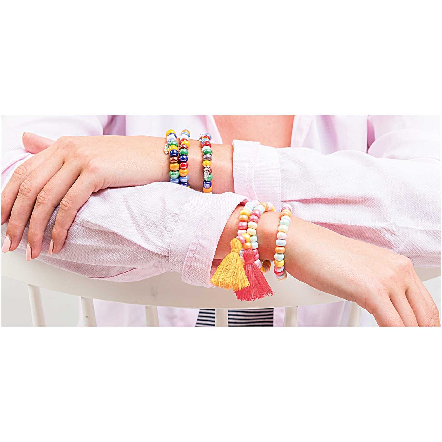 Glasperlen chalk terra pastell 8x5,5mm: Frau trägt bunte Armbänder aus Glasperlen, passend zu sommerlicher Kleidung.