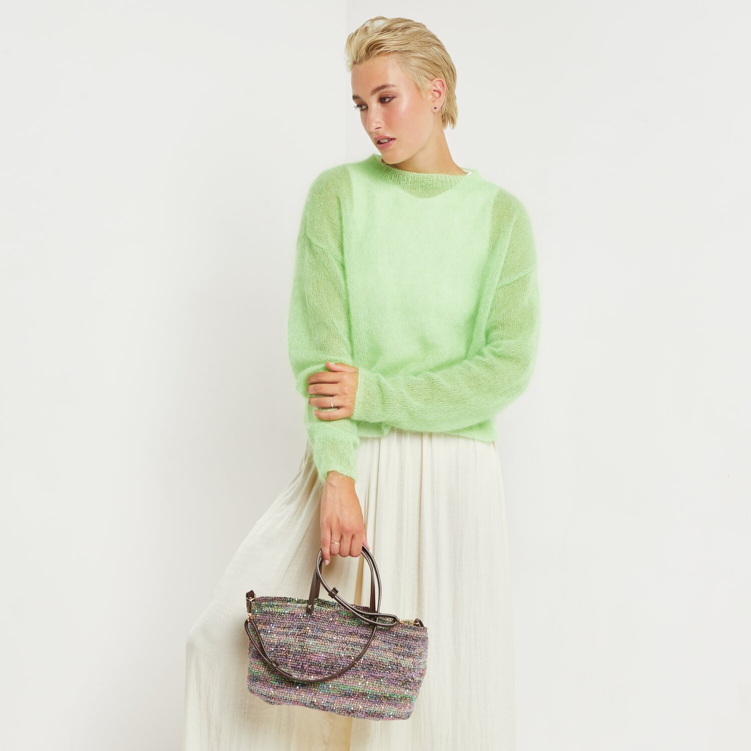 Made by Me No. 20 Frühjahr-Sommer: Frau in pastellgrünem Pullover von Rico Design, hält eine Tasche, trägt einen langen Rock.