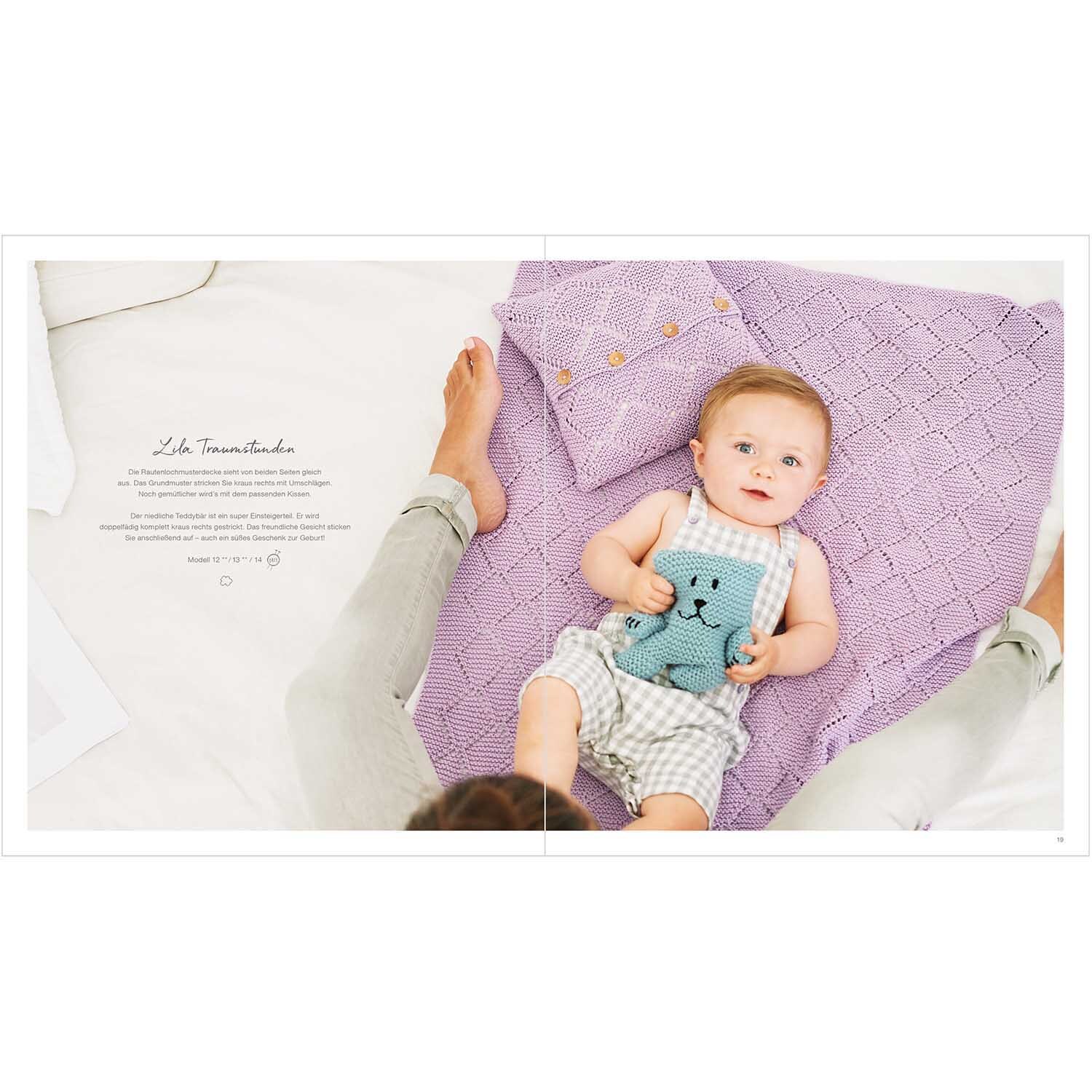 Rico Baby Heft Nr.30: Ein Baby liegt auf einer lila Decke und hält ein blaues Kuscheltier.