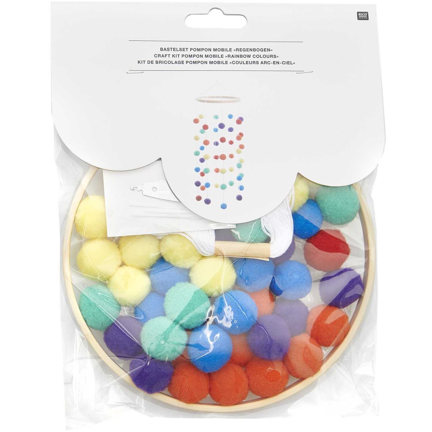 Bastelset Pompon Mobile regenbogen von Rico Design zeigt bunte Pompons in einem Holzring.
