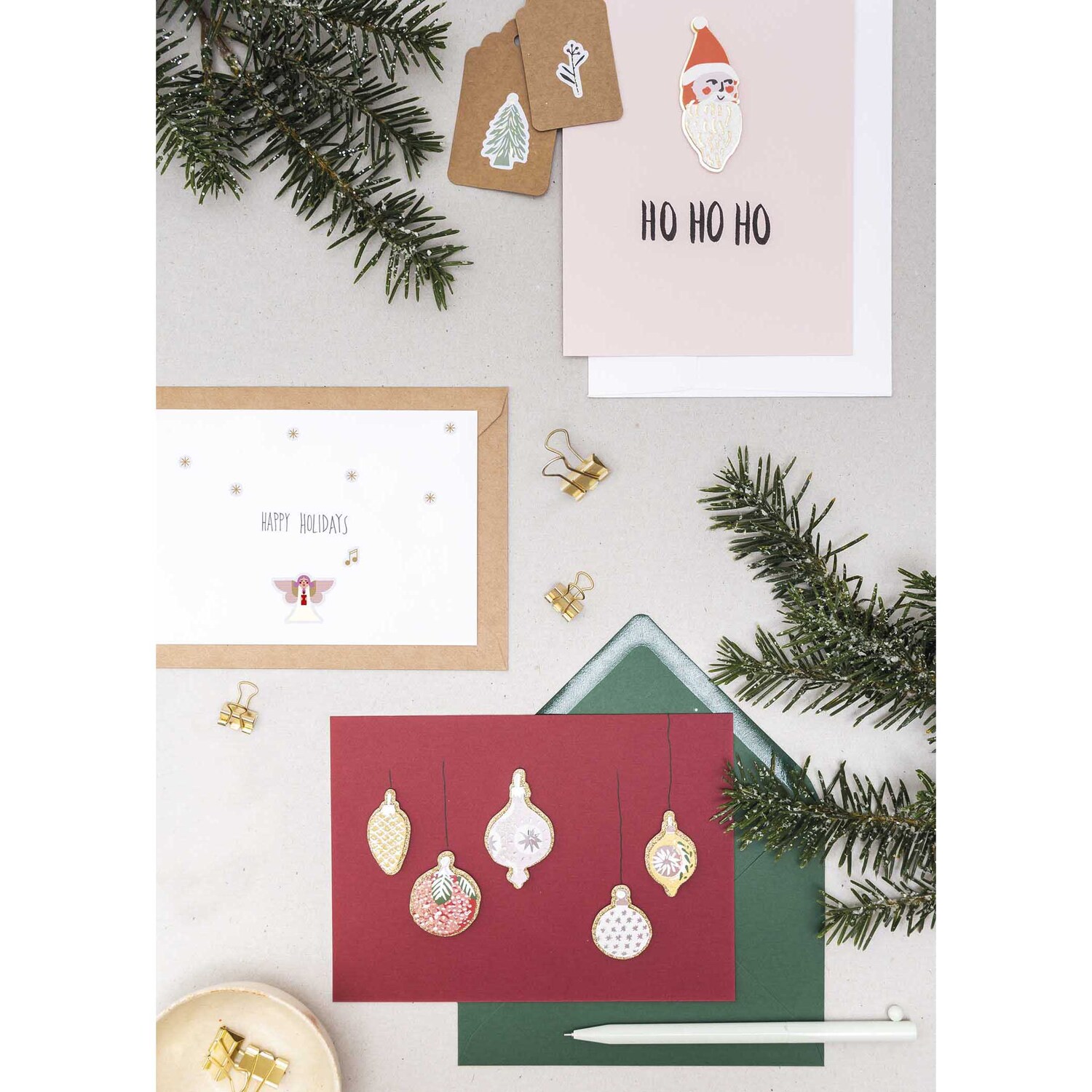Paper Poetry Gelsticker Engel 1 Blatt: Mehrfarbige Weihnachtskarten mit festlichen Motiven und Dekorationen auf einem Tisch arrangiert.