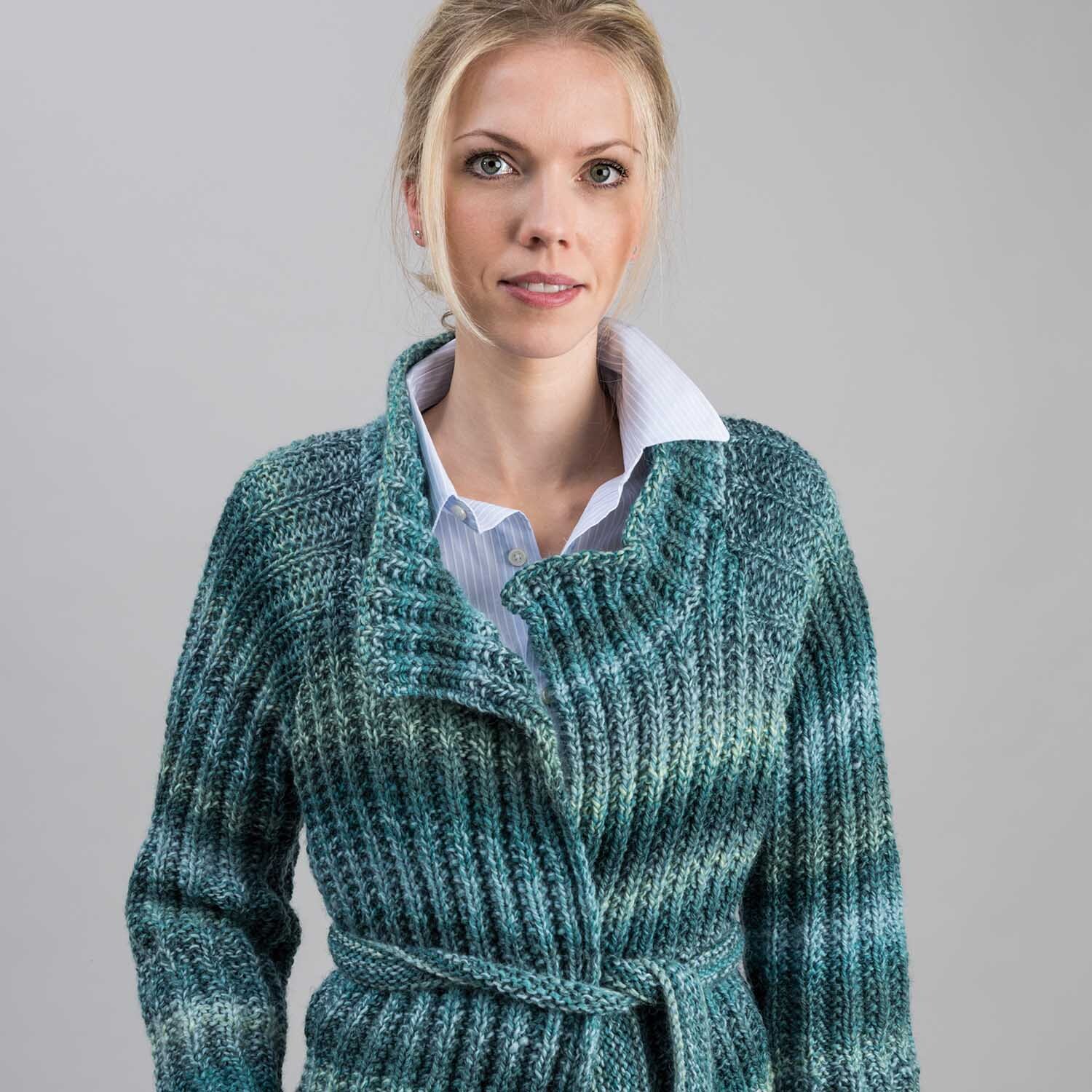 Strickanleitung Jacke aus Creative Ito Iro chunky: Frau trägt gestrickte, blau-grüne Jacke mit Gürtel.