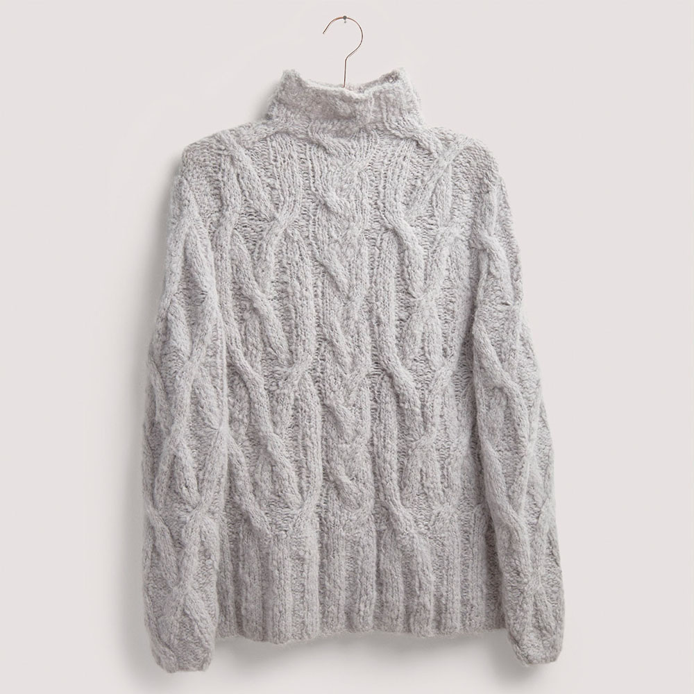 Zopfmuster-Pullover auf grauem Hintergrund – zum Strickset