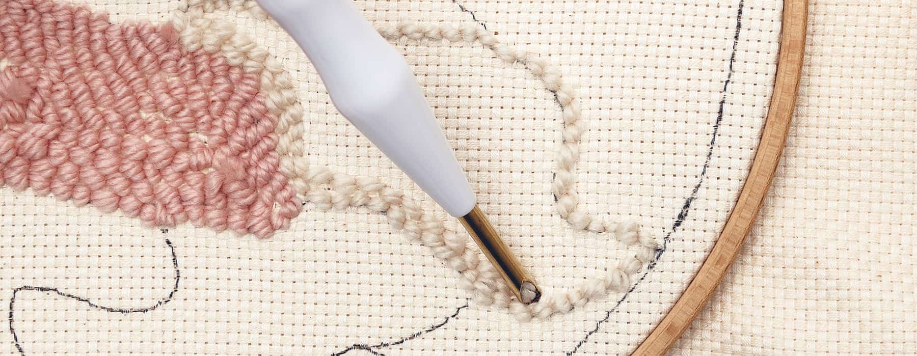 Punch Needle stickt Wolle in einen Stoff
