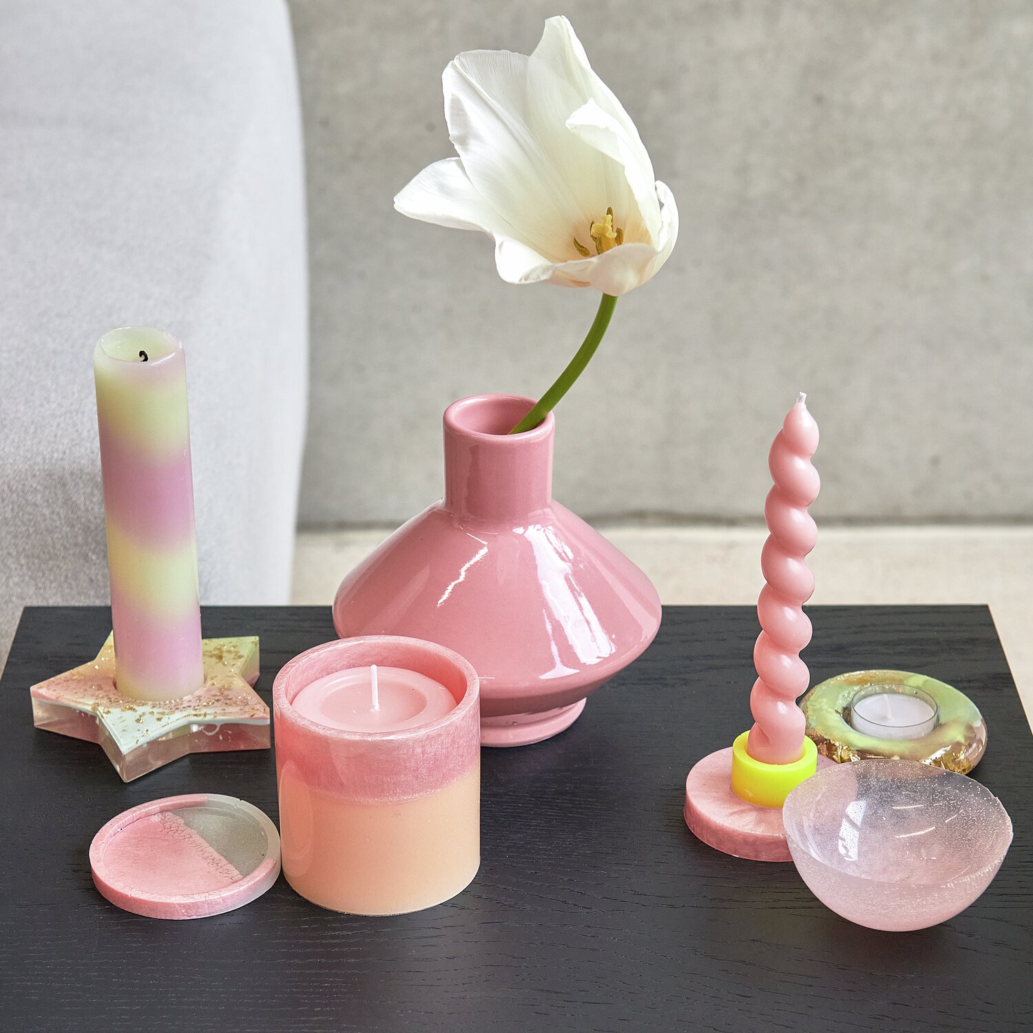 Farbpigmente für Resin mit Perl-Effekt: Rosa Kerzen und Vasen auf schwarzem Tisch, dekorativ arrangiert.