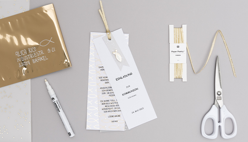 Bastelanleitung Einladung zur Kommunion und Konfirmation: Materialien in Weiß und Gold auf grauem Hintergrund. Enthält Schere, Stift und Papier.