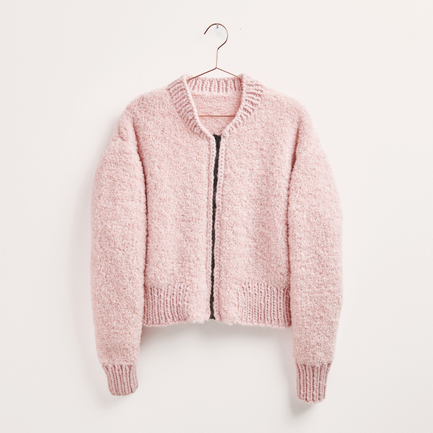 Strickset Jacke Modell 11 aus Made by Me No. 19, rosa, an einem Kleiderbügel hängend, von Rico Design.