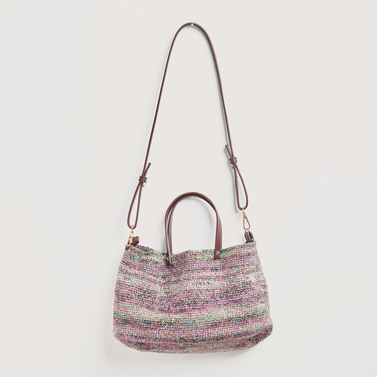 Häkelset Tasche Modell 23 zeigt eine stilvolle Tasche aus der Frühjahr-Sommer-Kollektion von Rico Design, verziert mit Blumen und Pailletten.
