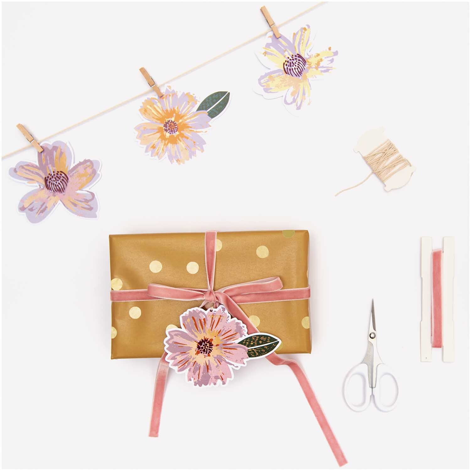Paper Poetry Papieranhänger Blüten 8 Stück: Bunte Blütenanhänger von Rico Design, dekorativ an Geschenk und Leine befestigt.