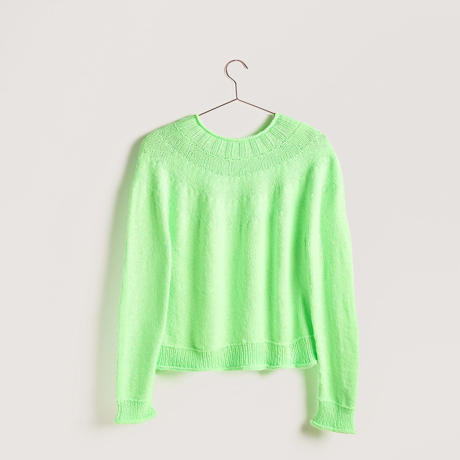 Strickset Pullover Modell 03b aus Vegan Cashmere in leuchtendem Grün auf einem Kleiderbügel.