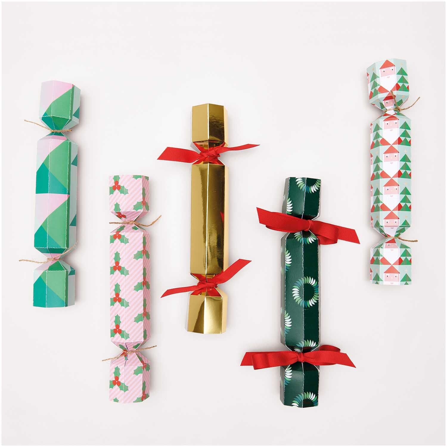 Paper Poetry Motivpapierblock Merry Christmas 25 Blatt von Rico Design. Fünf festliche Knallbonbons in verschiedenen Mustern und Farben, dekoriert mit roten Schleifen.