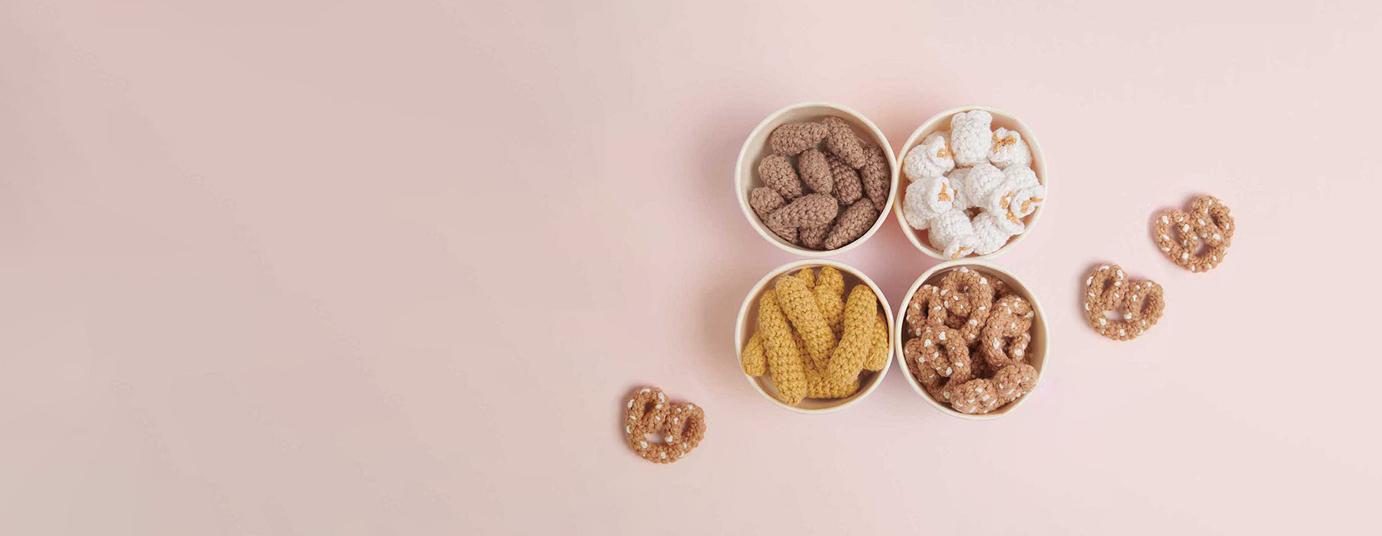 Gehäkelte Mandeln, Popcorn, Erdnüsse und Brezel in Papierschälchen. Häkelfiguren aus Ricorumi Snacks.
