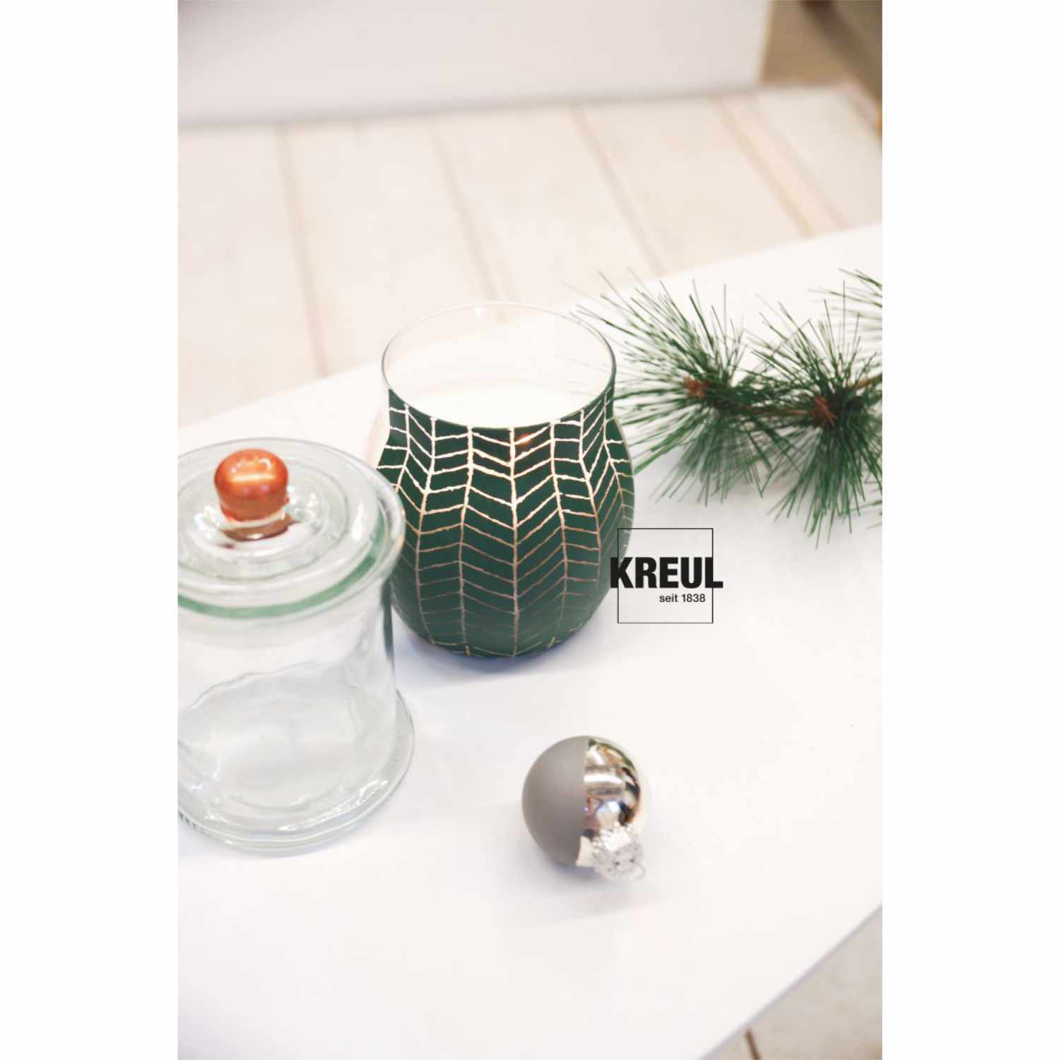 Glas- und Porzellanfarben Set Chalky: Grünes Glas mit geometrischem Muster, dekoriert mit Tannenzweig und Kugel. Ideal für kreative Designs.