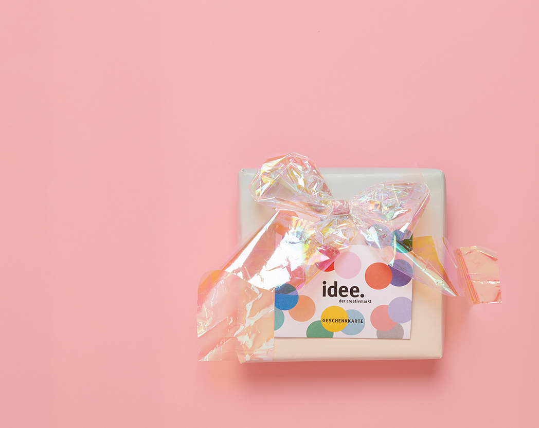 idee. Geschenk-Karte liegt auf einem kleinen Geschenk. Flatlay von Produkten.