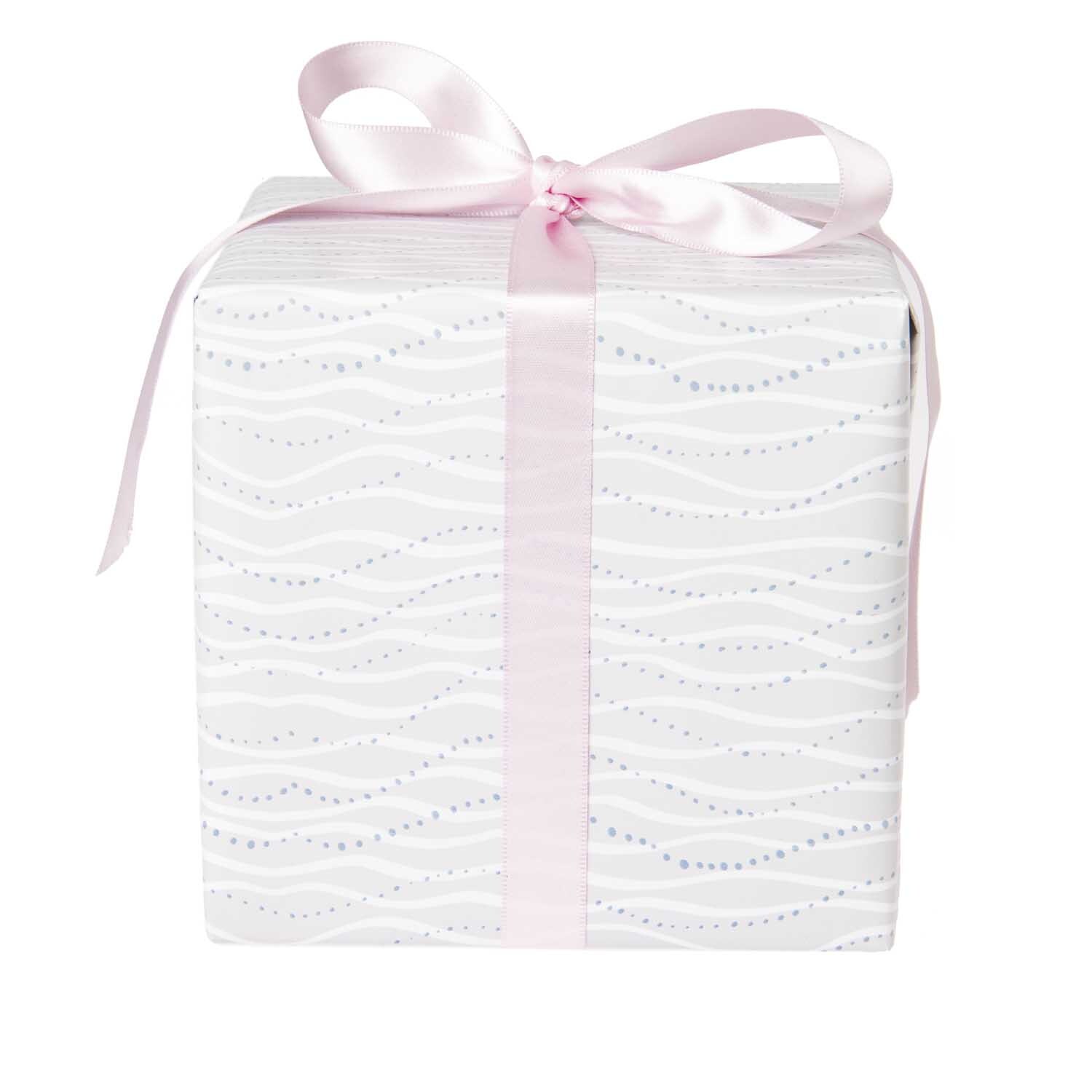Paper Poetry Geschenkpapier zeigt zarte Wellenmuster in Weiß, verpackt mit rosa Schleife. Ideal für elegante Geschenke. Marke: Rico Design.