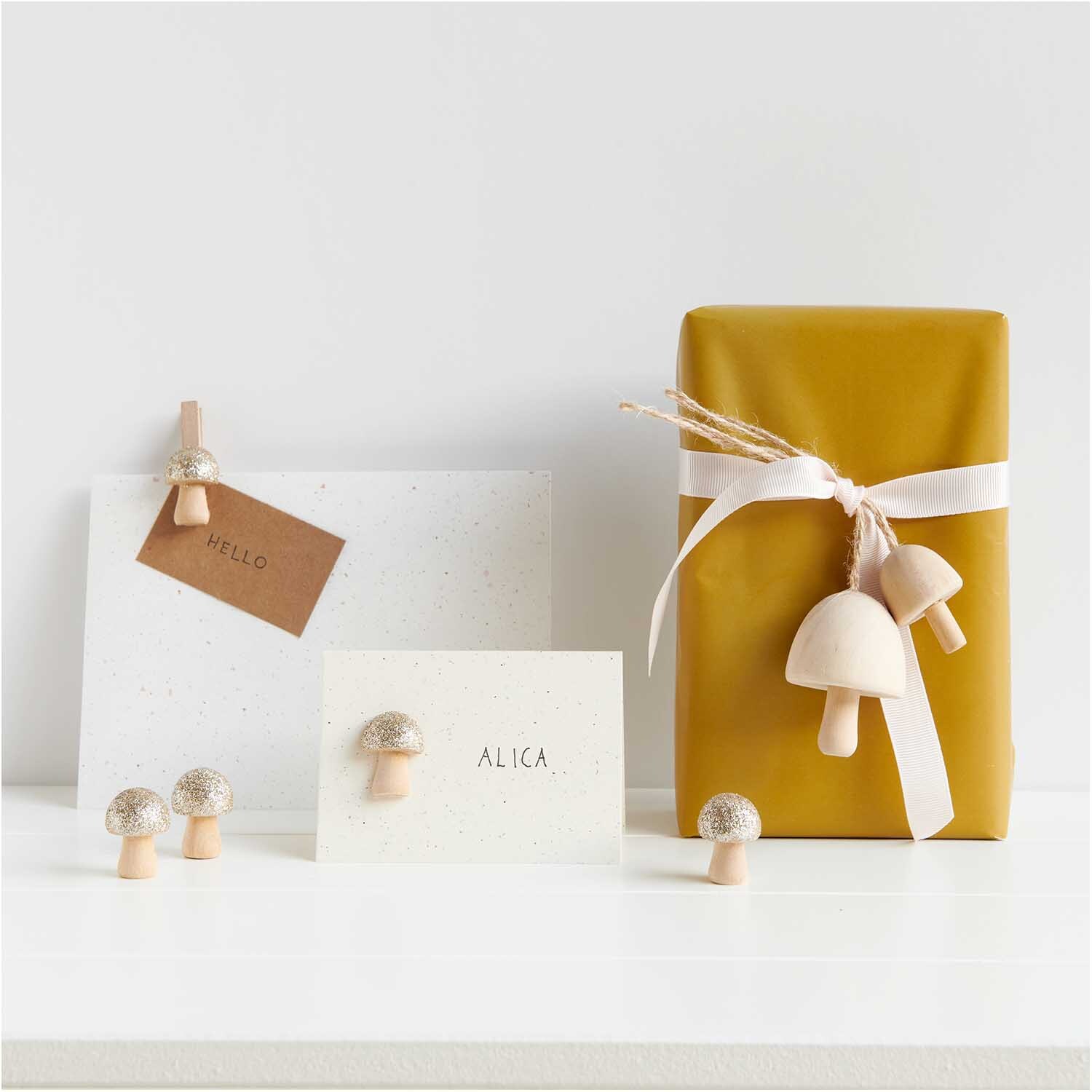 3D-Holzstreu Pilz mit Glitter natur-gold, dekorativ auf Karten und Geschenk arrangiert.