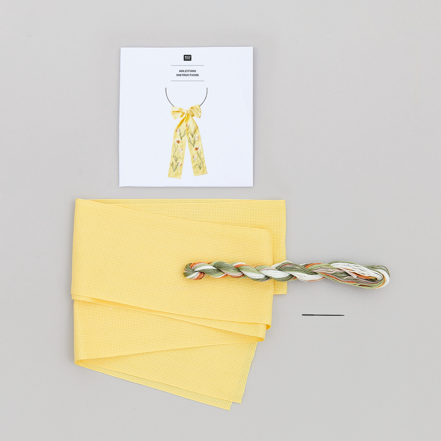 Stickpackung Schleife Narzissen, Rico Design: Gelbes Stoffset mit Garn und Nadel, ideal für kreative Handarbeiten.