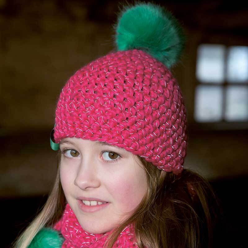 Creative Glühwürmchen Mütze in leuchtendem Pink mit grünem Bommel, ideal für kalte Tage.