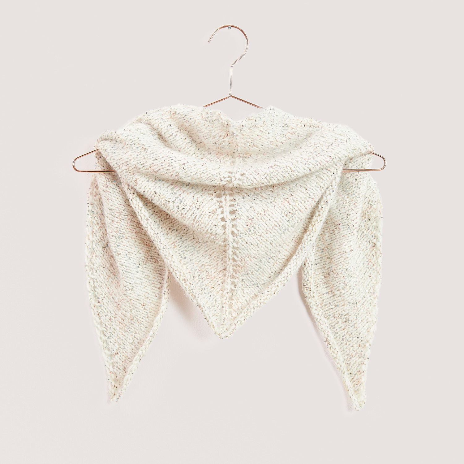 Strickset Dreieckstuch Modell 05b aus Mini Tücher Special, beige, auf einem Kleiderbügel.
