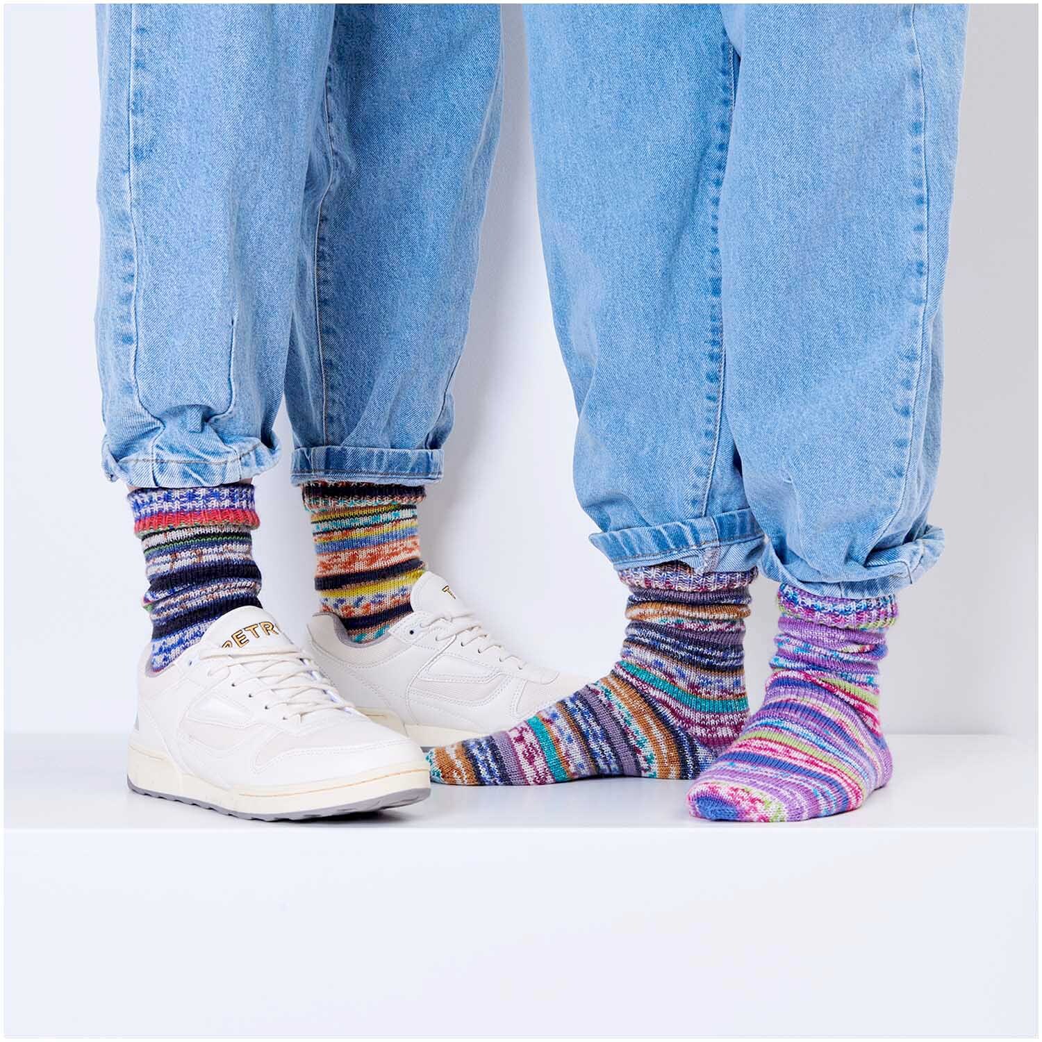 Superba Fair Isle 4-fädig Socken in bunten Mustern, getragen mit Jeans und weißen Sneakern.