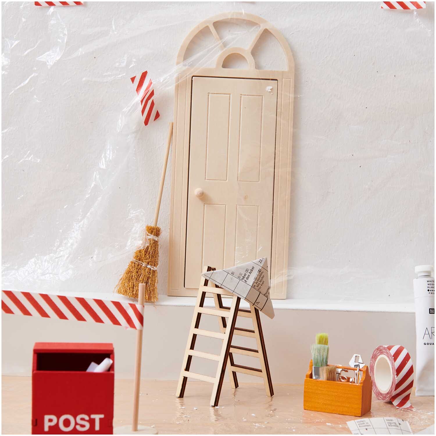 Miniatur Wichteltür mit Bogen 10x23,8cm von Rico Design, umgeben von Leiter, Besen und Postbox.