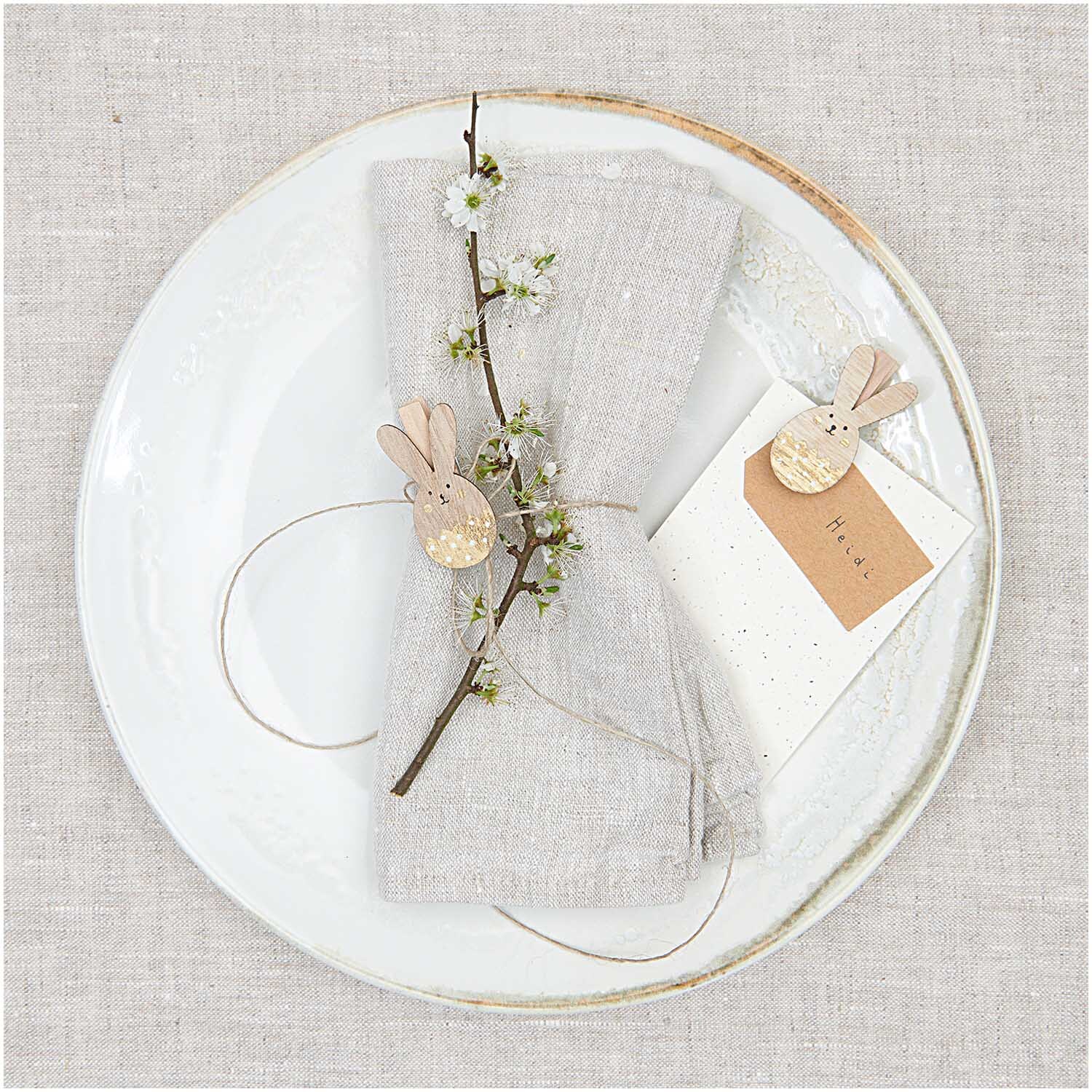 Dekoklammern Osterhase 4 Stück: Elegante Tischdeko mit goldenen Hasenklammern und Blumen.