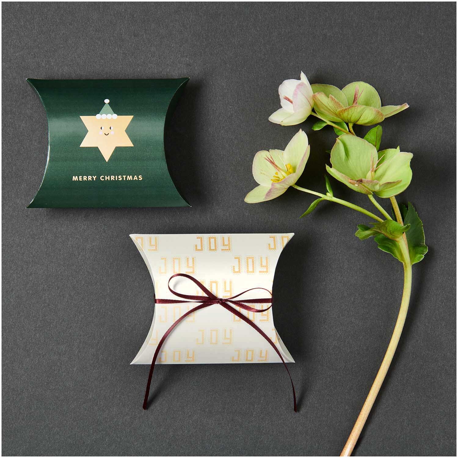 Paper Poetry Geschenkschachteln I love Christmas, grün und weiß, mit Blumenarrangement auf grauem Hintergrund.