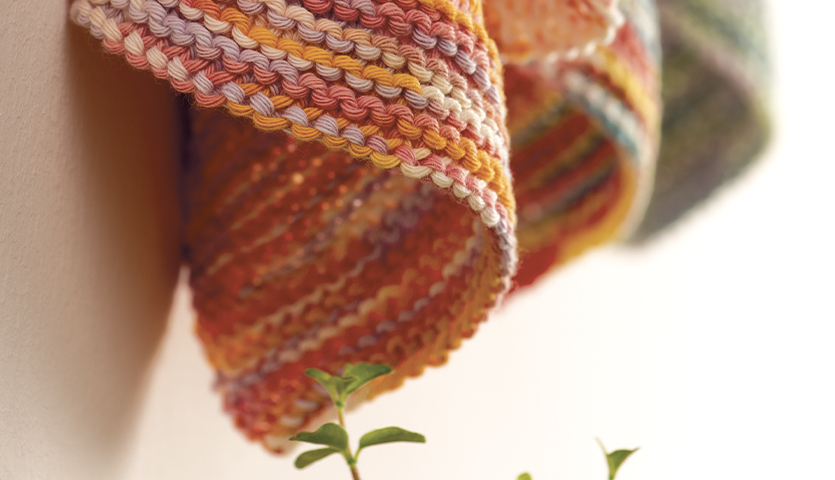 Strickanleitung für bunte Topflappen aus Creative Cotton Print, ideal für kreative Küchendekoration.